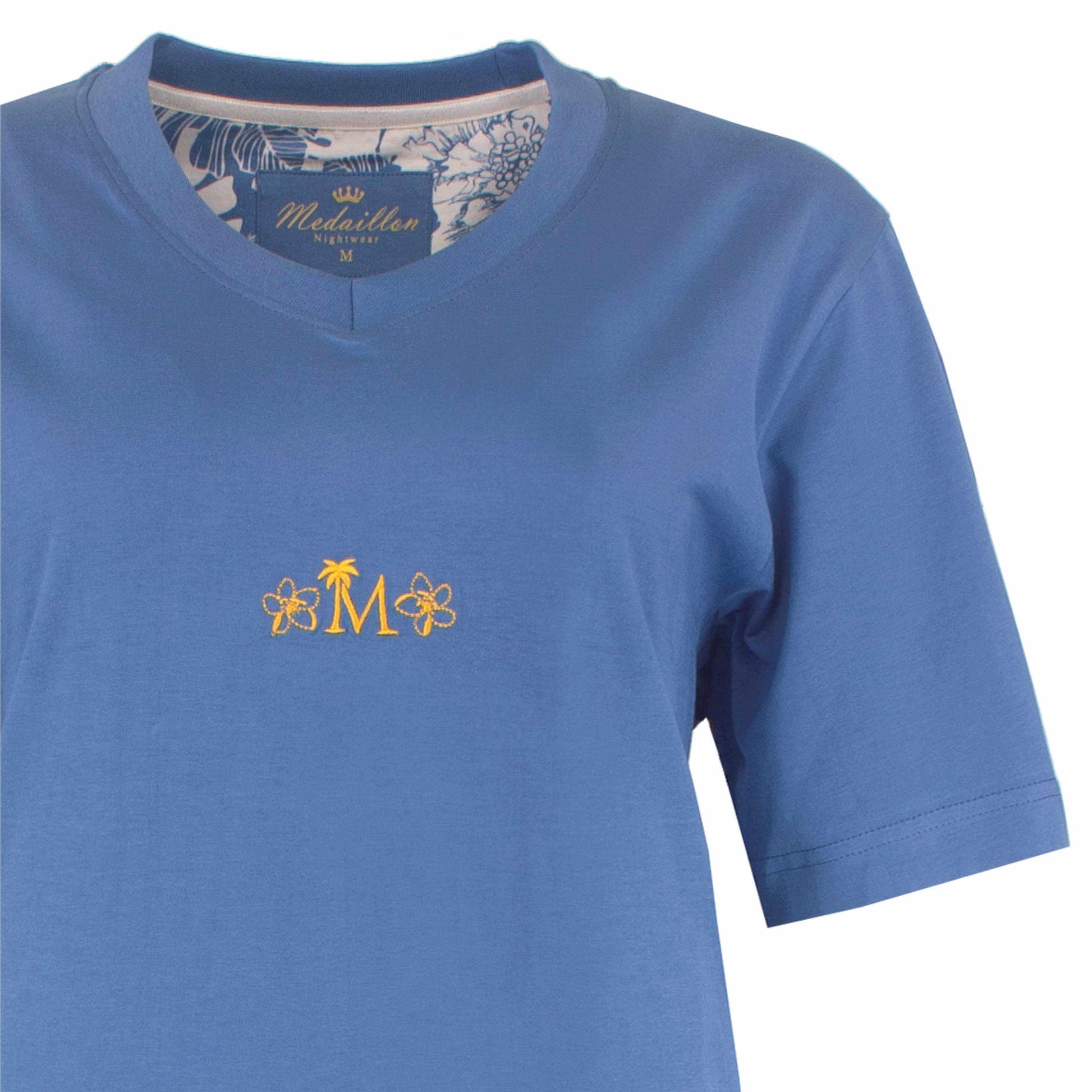 Lichtblauw dames nachthemd met korte mouwen en goudkleurig 'M' logo met bloemen op de borst