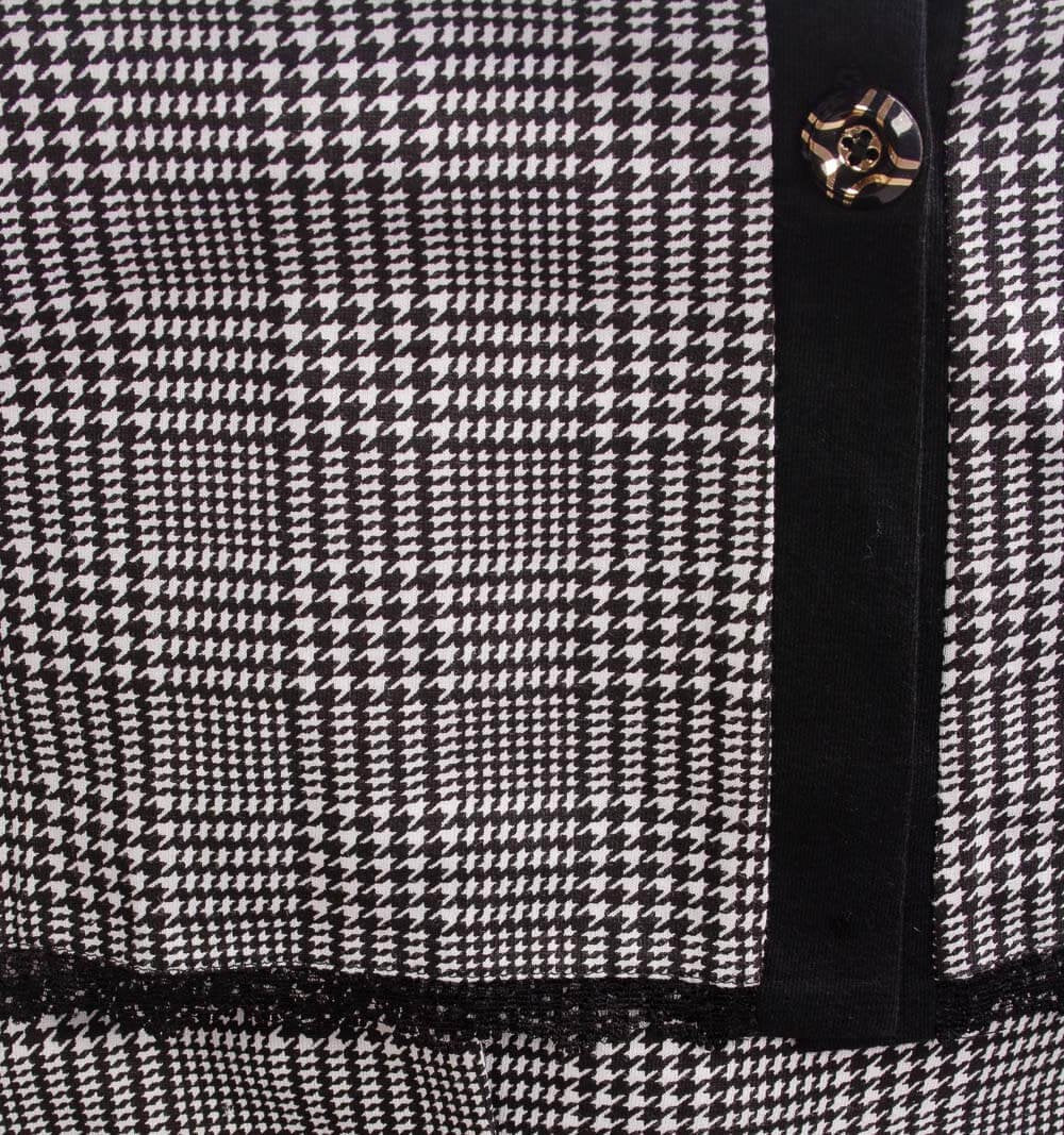 Zwart-wit ruitpatroon nachthemd met zwarte rand en goudkleurige knoop, close-up van stof en sluiting
