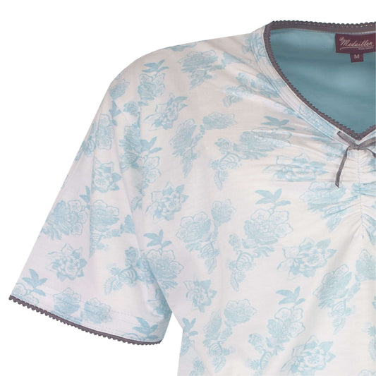 Dames pyjama top met lichtblauw bloemenpatroon op witte achtergrond, V-hals en korte mouwen met sierrand