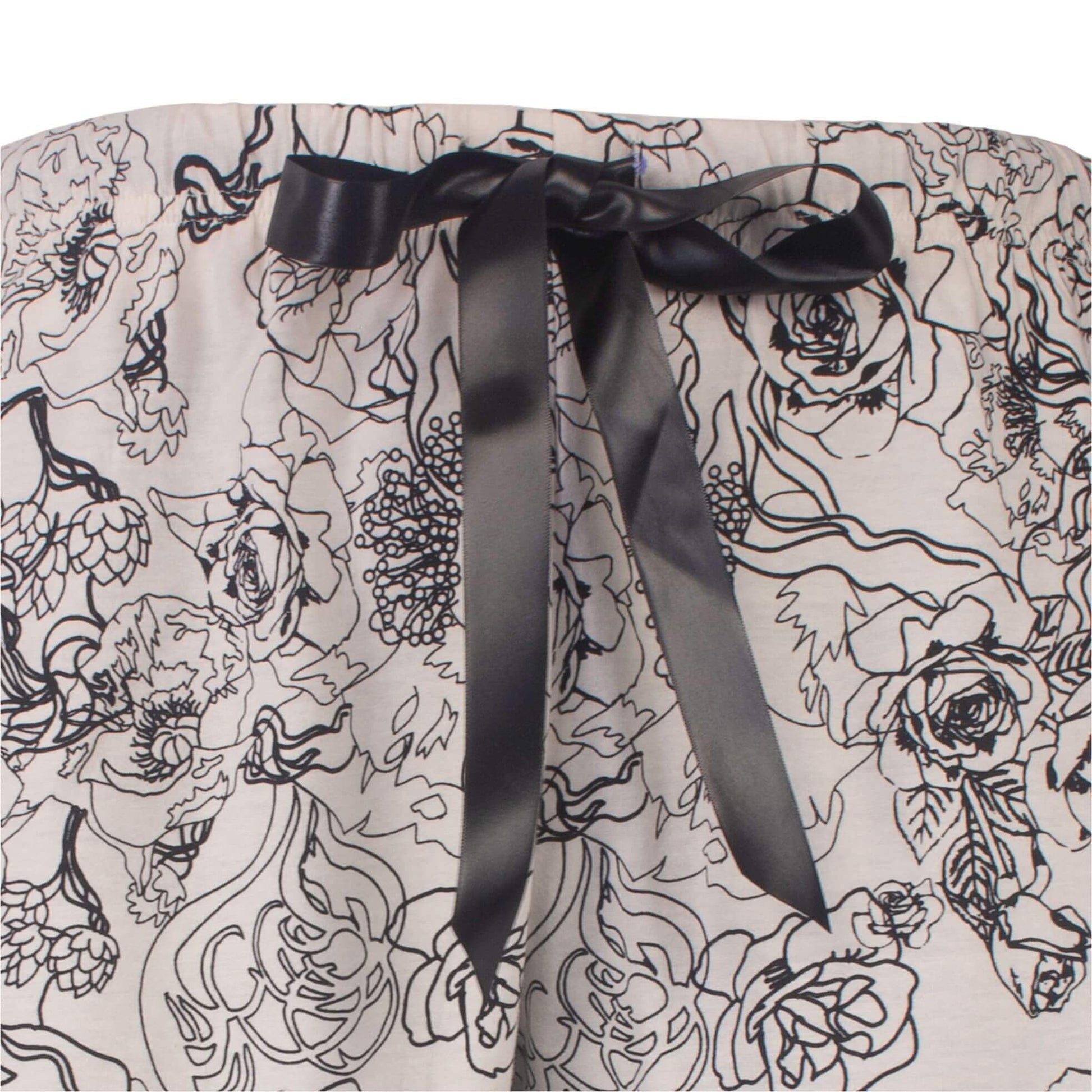 Grijze pyjama met zwarte bloemenprint en een zwart satijnen lint als tailleband detail.