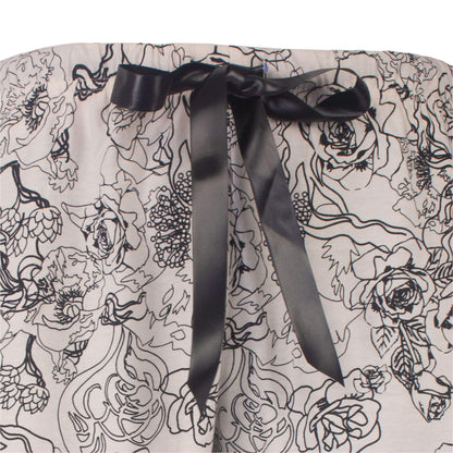 Grijze pyjama met zwarte bloemenprint en een zwart satijnen lint als tailleband detail.