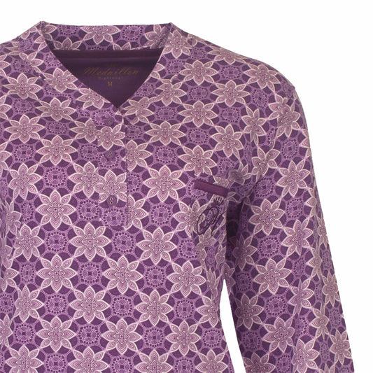 Lila dames pyjama met lange mouwen, versierd met een patroon van witte bloemmotieven over het hele kledingstuk.