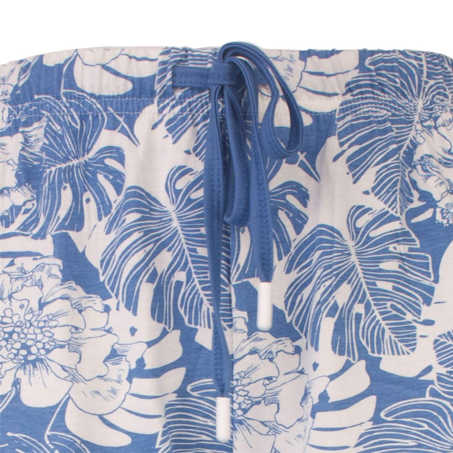 Lichtblauwe pyjama met wit bloemen- en bladpatroon. Elastische taille met blauw koord zichtbaar.