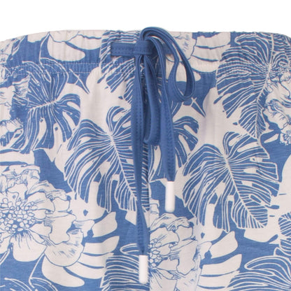 Lichtblauwe pyjama met wit bloemen- en bladpatroon. Elastische taille met blauw koord zichtbaar.