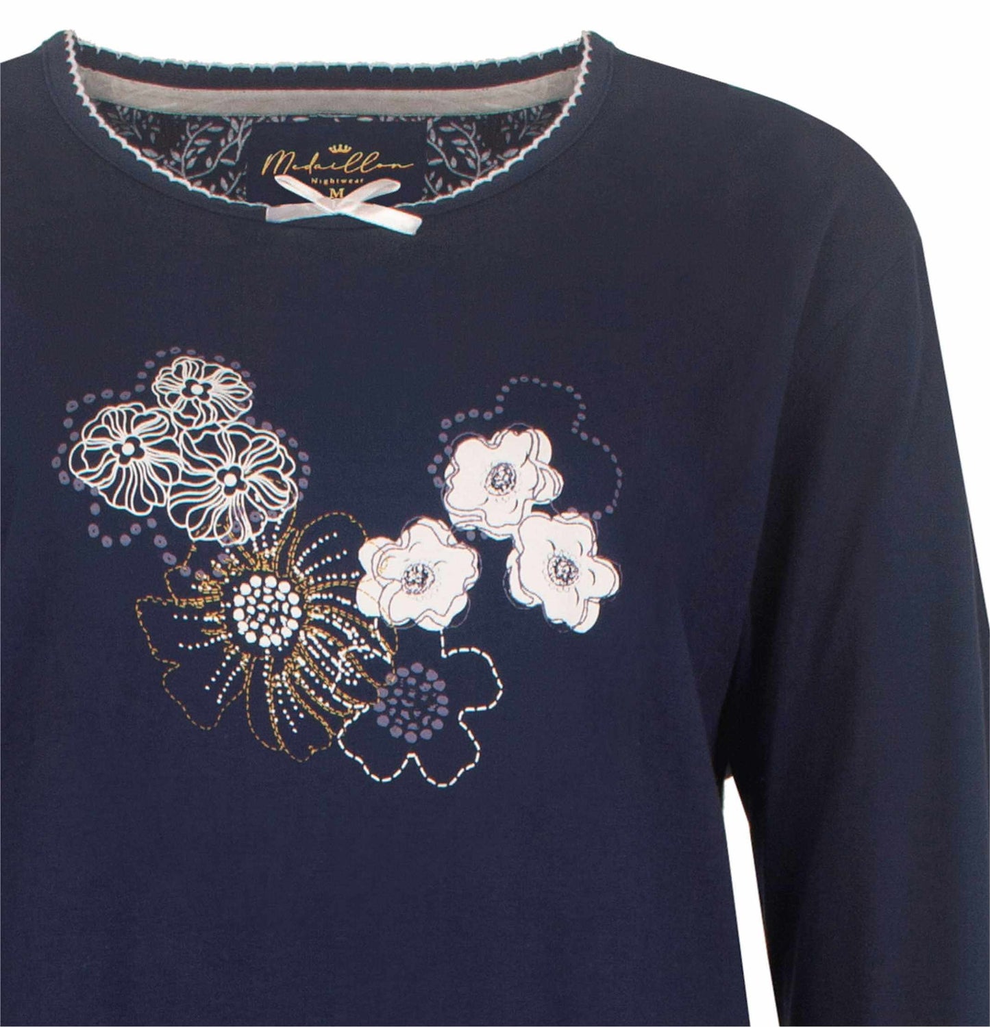 Donkerblauwe dames pyjama met witte en goudkleurige bloemenprint op de voorkant, merk Medaillon zichtbaar.