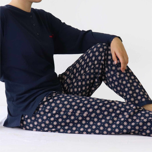 Dames pyjama met navy blauwe top en gebloemde broek. De top heeft een polo sluiting en lange mouwen.
