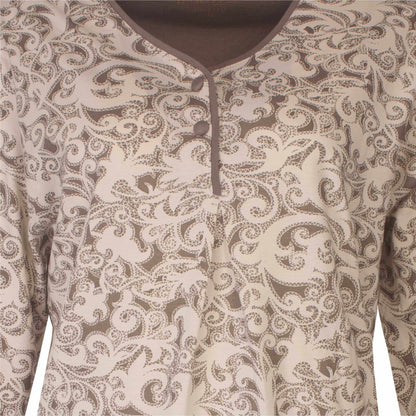 Close-up van een dames pyjama met een sierlijk bruin en crème ornamentpatroon en een gedeeltelijke halsopening met knoopjes.