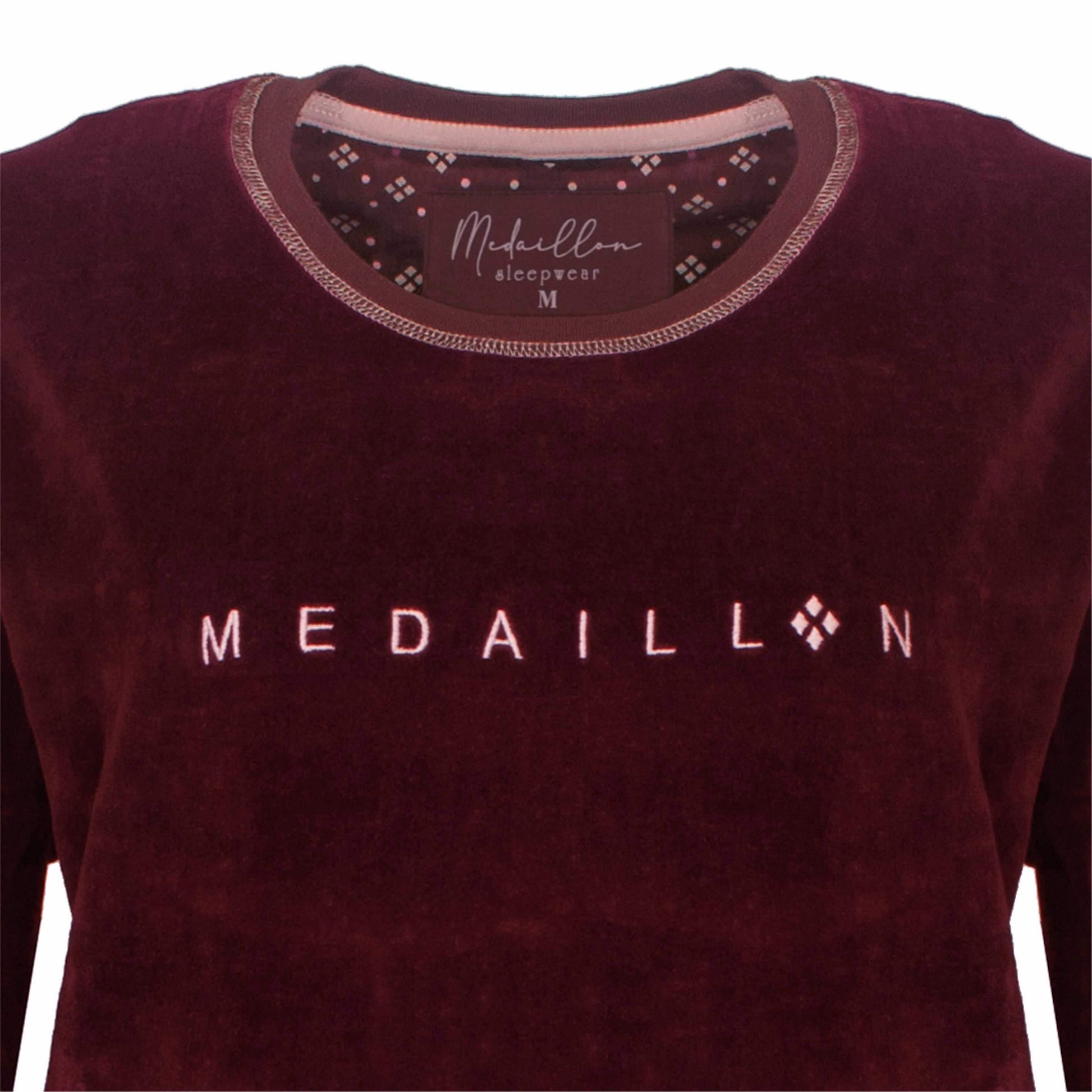 Bordeauxrode fluwelen pyjama top met 'MEDAILLON' opdruk in roze letters en decoratief patroon in de kraag