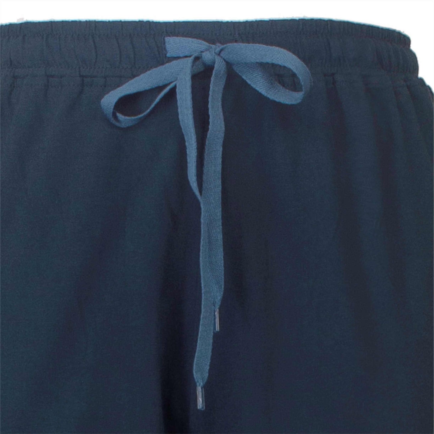 Close-up van een donkerblauwe pyjama broek met een lichtblauw koord als tailleband sluiting.