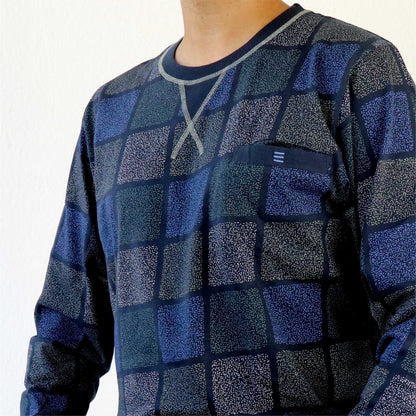 Close-up van een blauwe geruite pyjama met ronde hals, getoond op een model van de borst naar beneden.