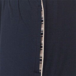 Close-up van donkerblauwe stof met een smalle opening die een lichtere gestreepte stof eronder onthult.