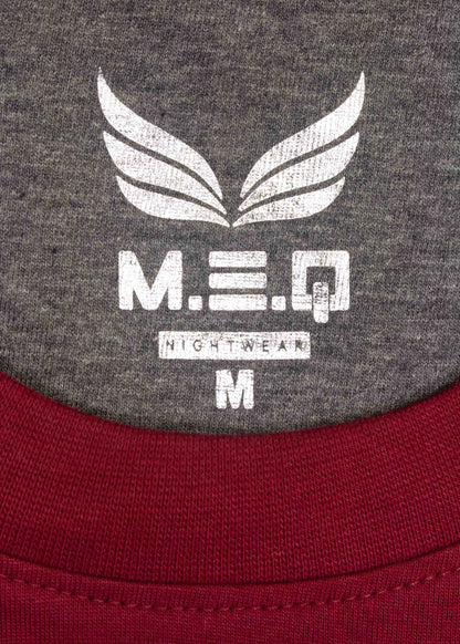 MEQ logo op grijze stof met witte vleugels, 'M.E.Q Nightwear M' tekst, rode stof zichtbaar onderaan