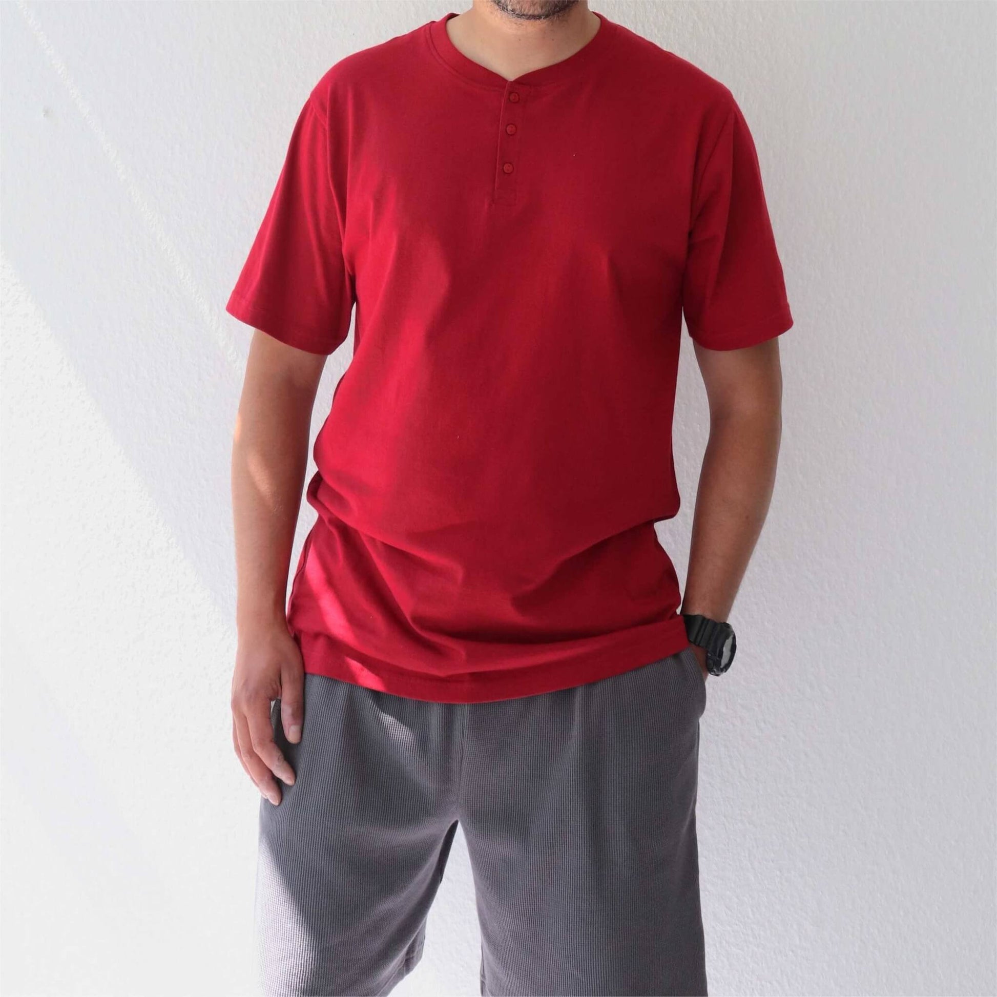Rode shortama met korte mouwen en knoopjes, gedragen met grijze korte broek. Casual zomerse pyjama set.