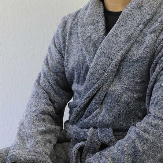 Close-up van een grijze fleece badjas met een comfortabele, zachte textuur en een gewikkelde voorkant.