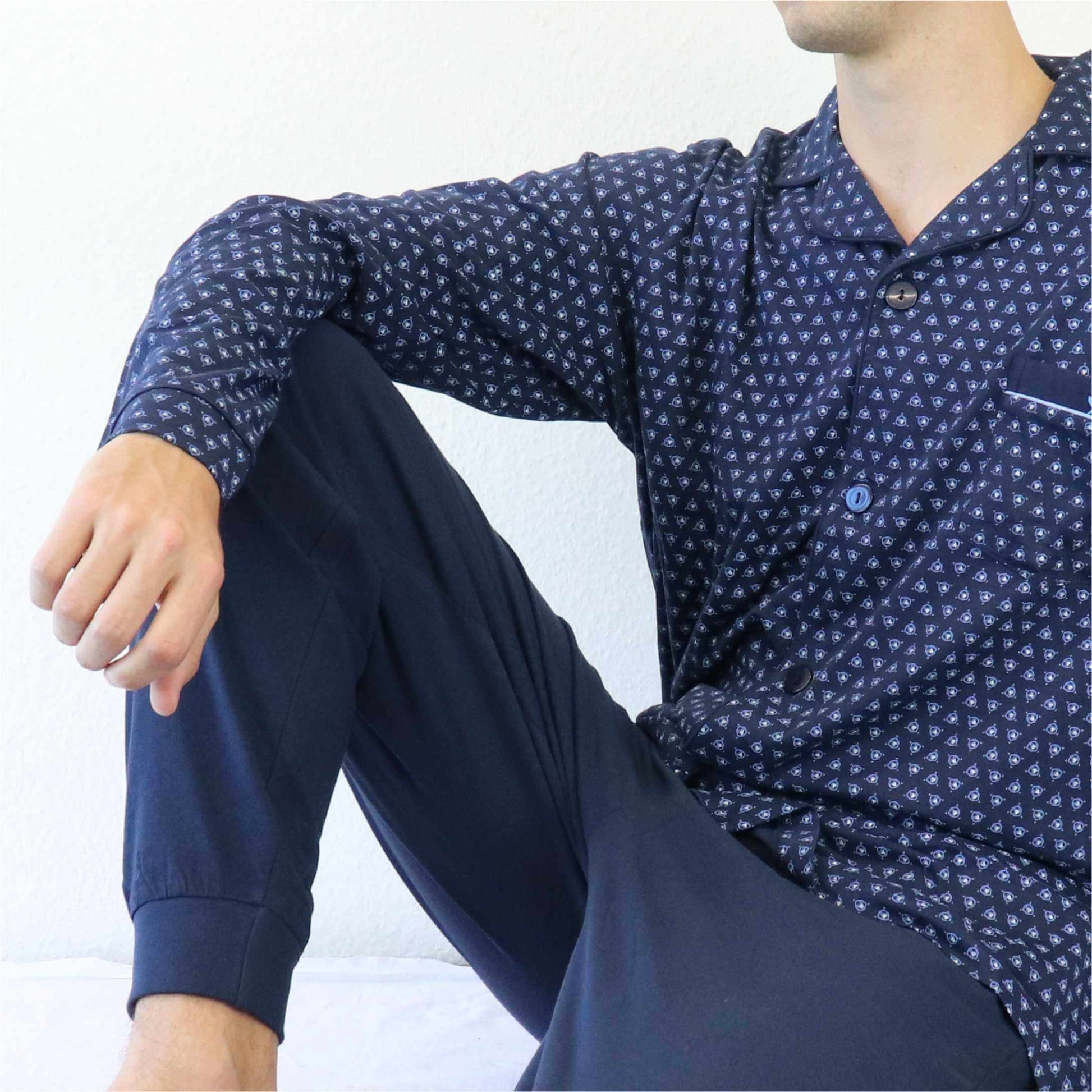 Blauwe doorknoop pyjama met klein geometrisch patroon. Knopen aan de voorkant en lange mouwen.