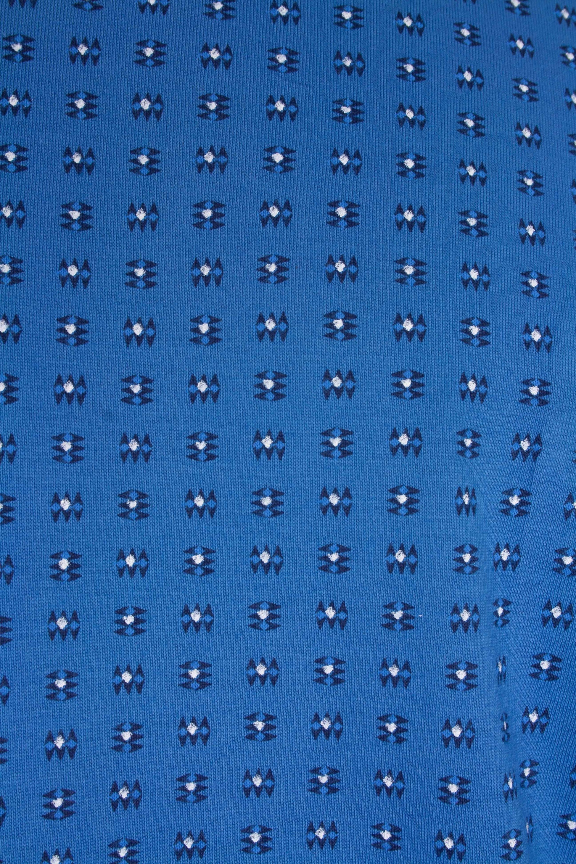 Blauw katoen met repetitief wit-donkerblauw bloemmotief, close-up van pyjamastof met kleine geometrische figuren