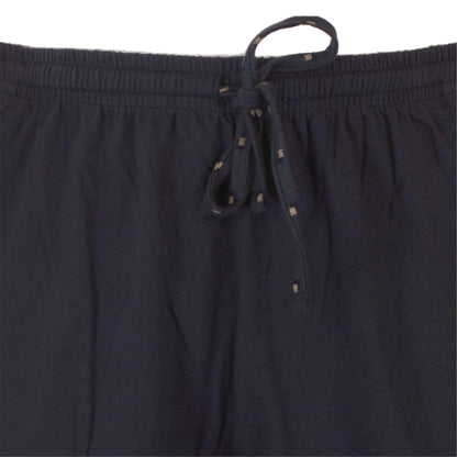 Close-up van een donkerblauwe pyjama broek met elastische tailleband en aantrekkoord met metalen uiteinden.