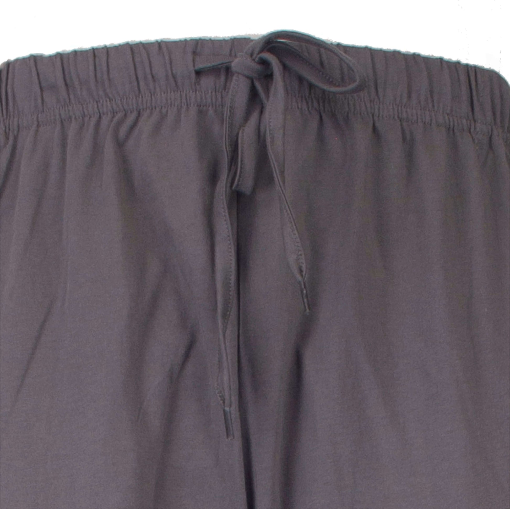 Close-up van een donkergrijze pyjamabroek met elastische taille en aantrekkoord aan de voorzijde.