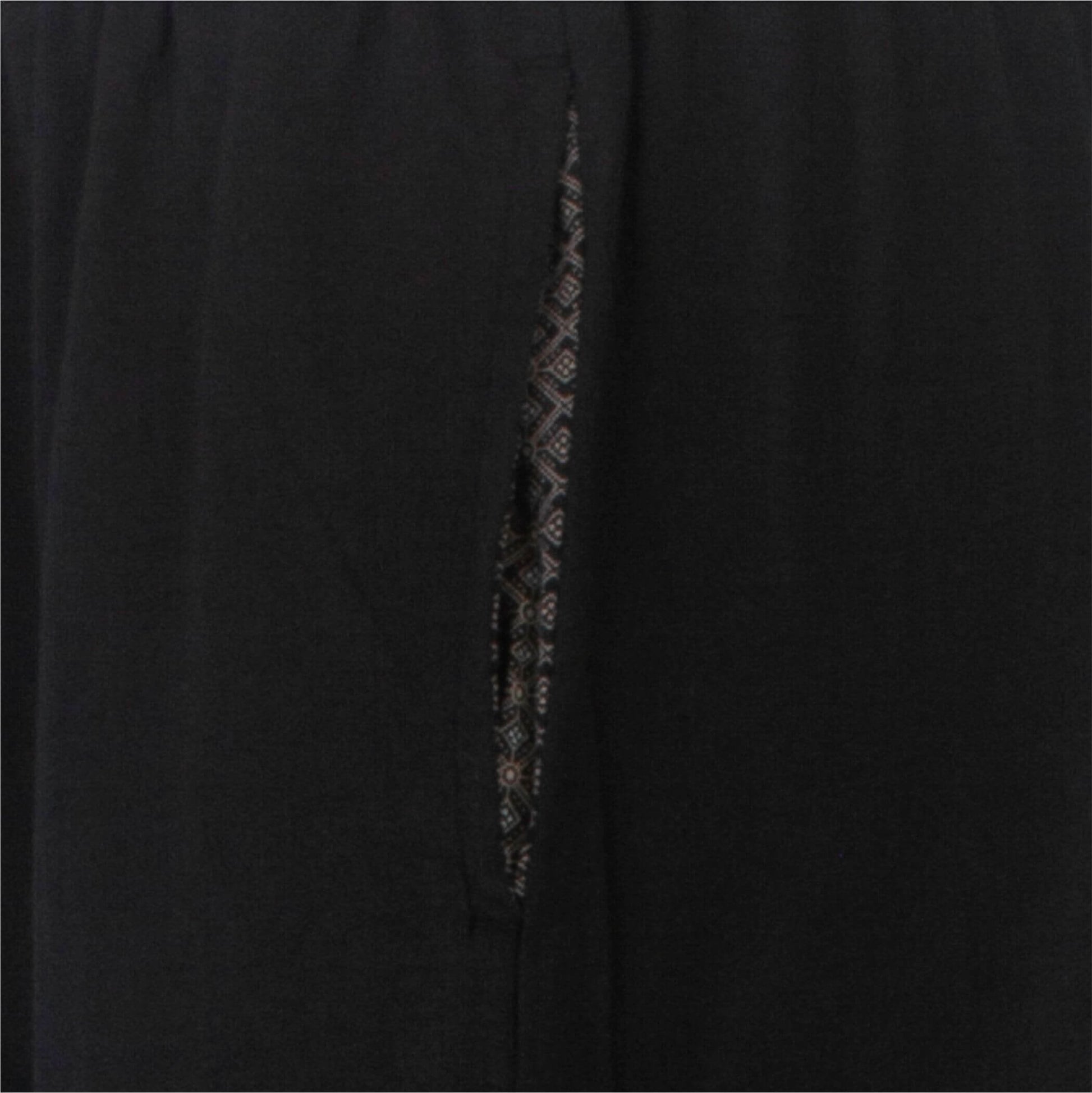 Close-up van donkergrijze pyjamastof met subtiel geprint dessin zichtbaar in de split of naad