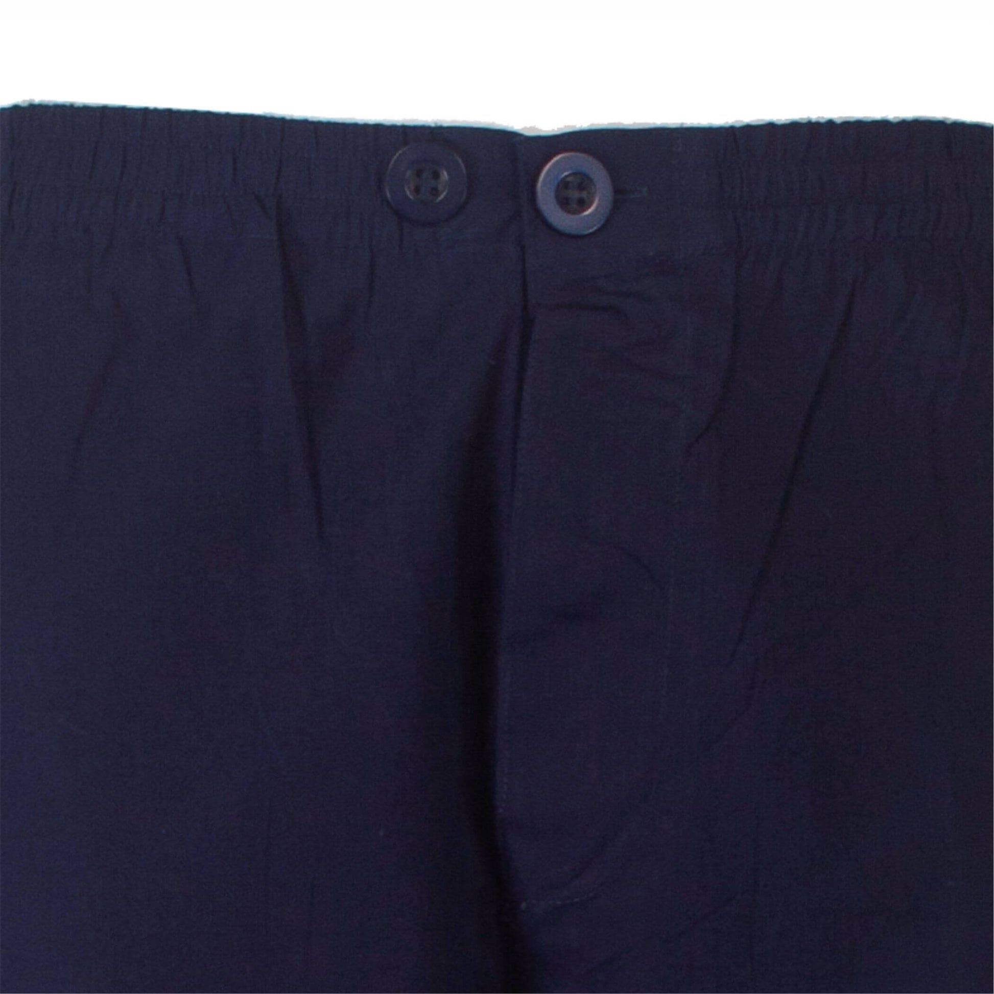 Close-up van de tailleband van een kobaltblauwe pyjama met twee knopen, gemaakt van een gladkreukt materiaal