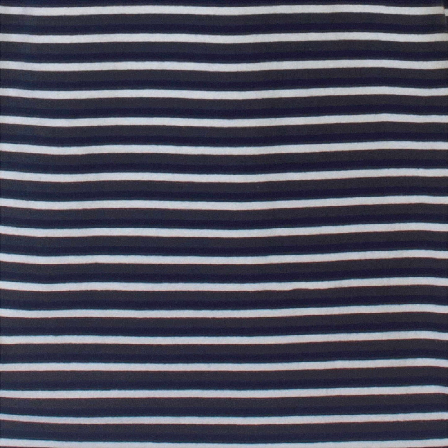 Close-up van gestreepte stof met donkerblauwe en witte horizontale lijnen, gebruikt voor een herenpyjama.