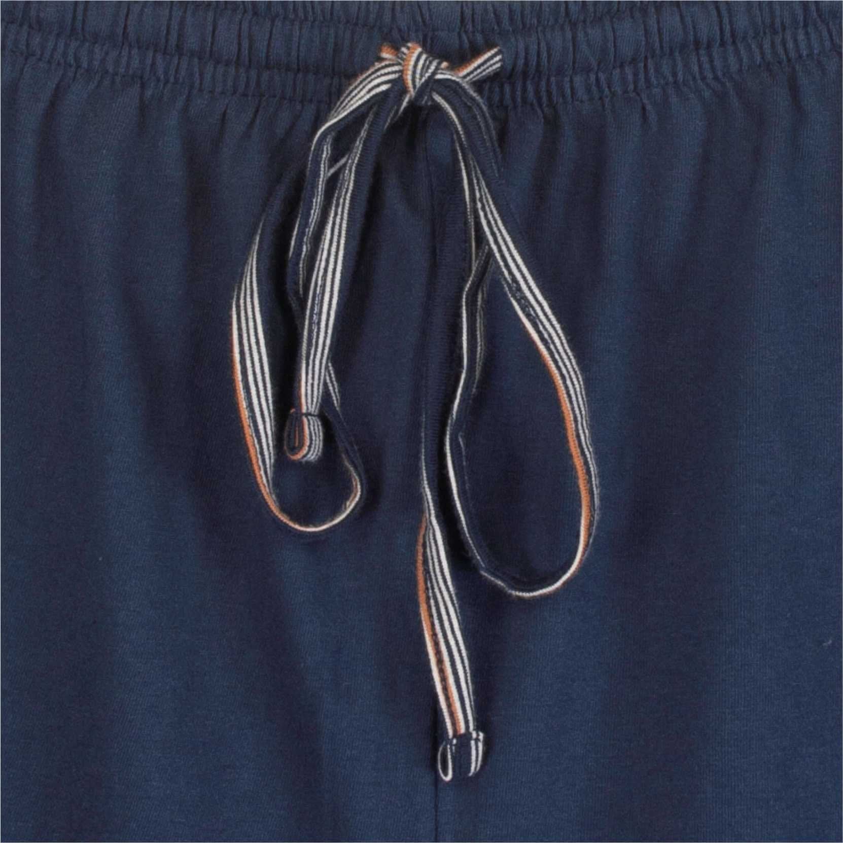Close-up van een gestreept koord van een blauwe pyjama, liggend op een donkerblauwe stof.