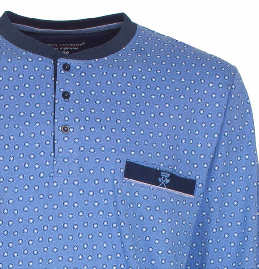 Lichtblauwe pyjama top met kleine gedrukte patronen, donkerblauwe kraag en zakje met logo