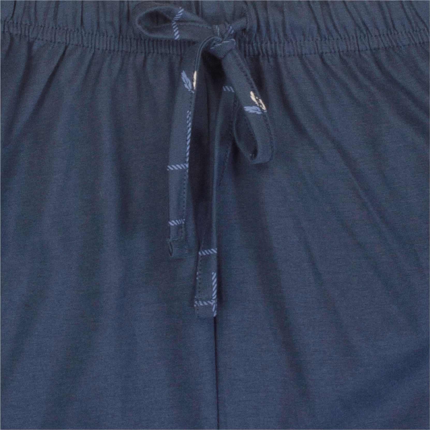 Close-up van een jeansblauw pyjama-broek met elastische band en aantrekkoord met gestreepte uiteinden