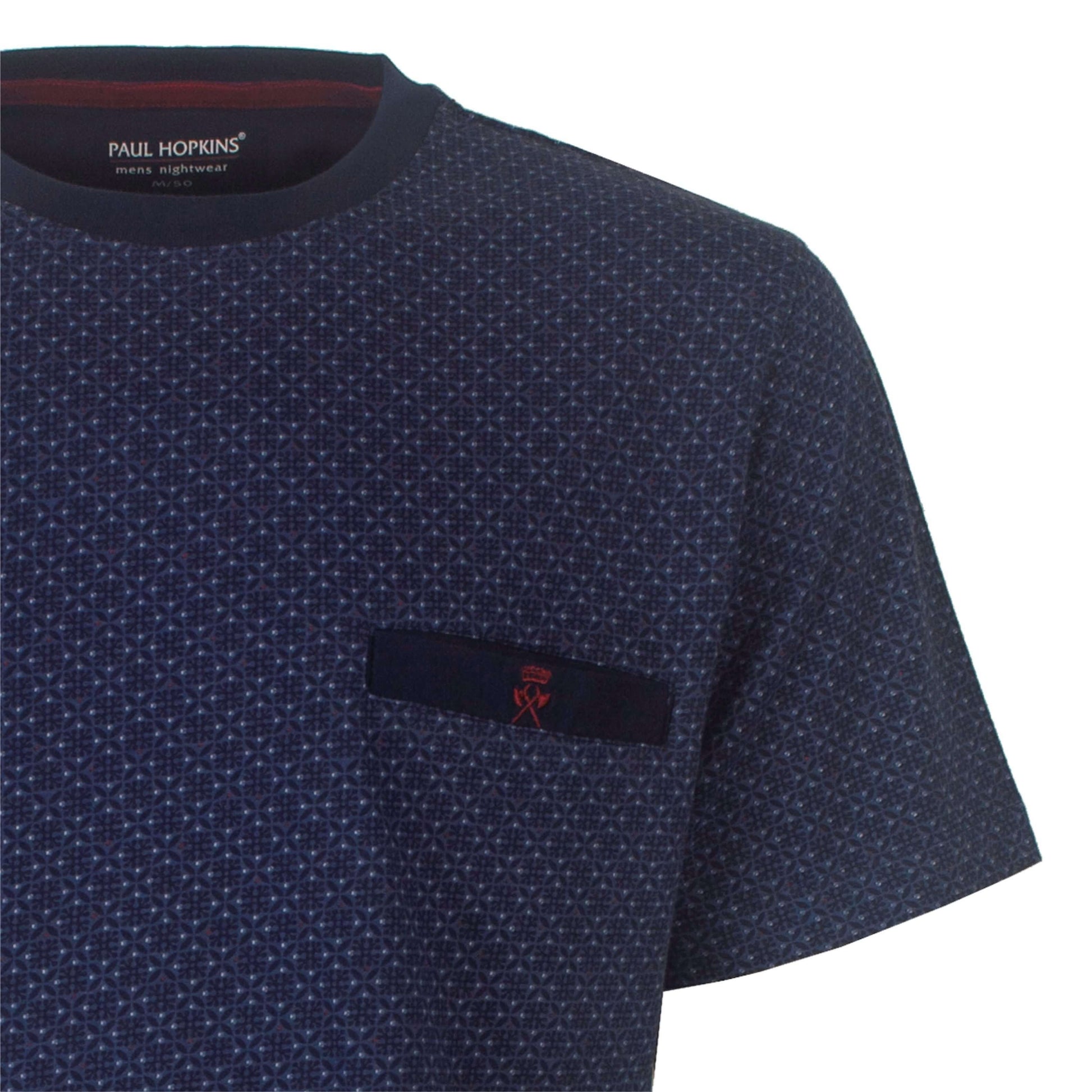 Close-up van een blauw herenT-shirt met een fijn geprint patroon en een klein donker label op de borst.