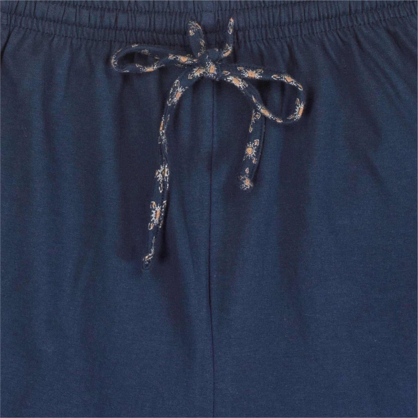 Close-up van een blauwe shortama met geprint koord. De stof heeft een subtiel geprint dessin.