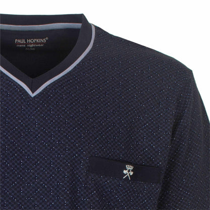 Close-up van een donkerblauwe pyjama top met V-hals en subtiel stippenpatroon, Paul Hopkins logo zichtbaar.