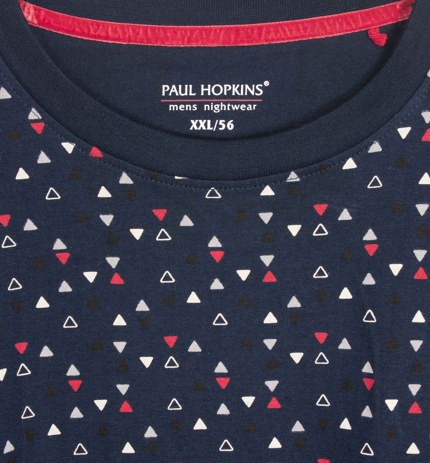 Donkerblauwe pyjama top met witte, rode en zwarte driehoekjes patroon. Paul Hopkins merk label zichtbaar.