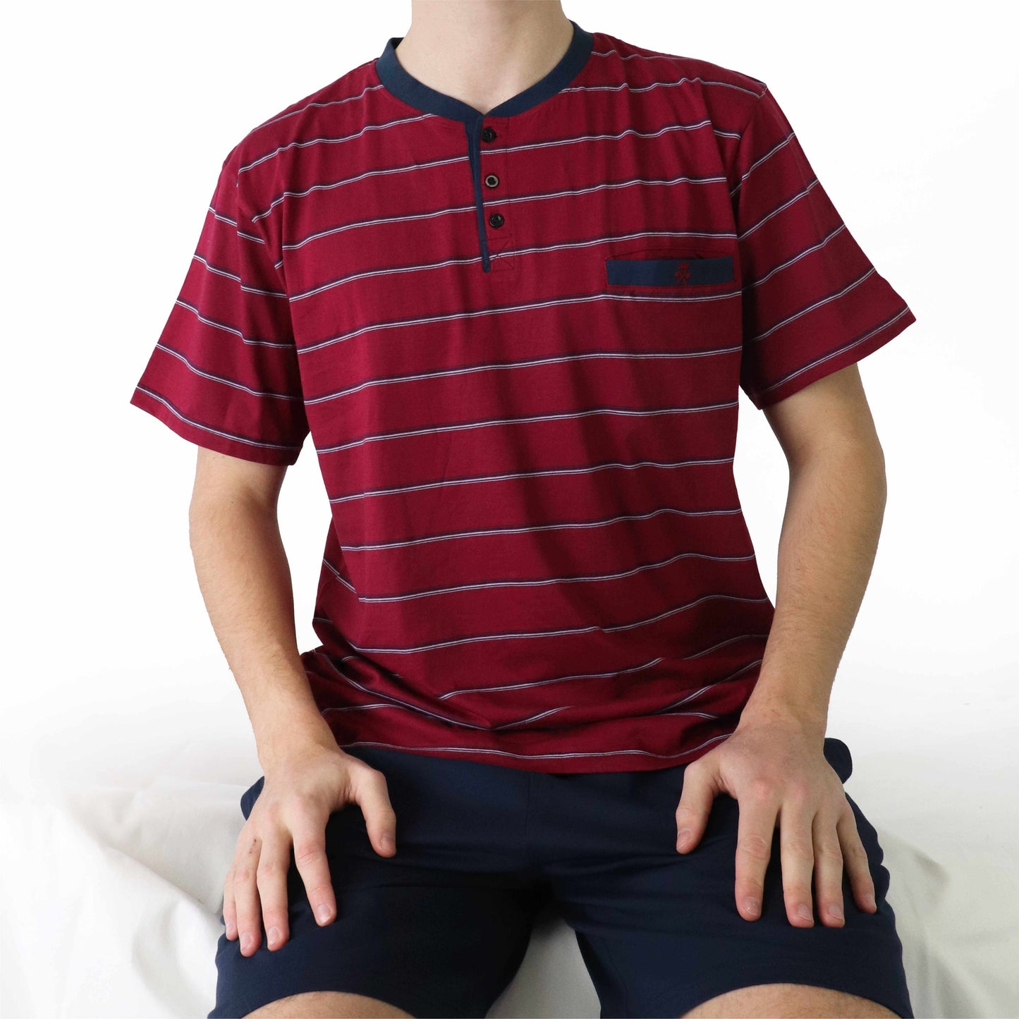 Rode gestreepte polo-shirt met korte mouwen en donkerblauwe kraag, gedragen met donkerblauwe shorts