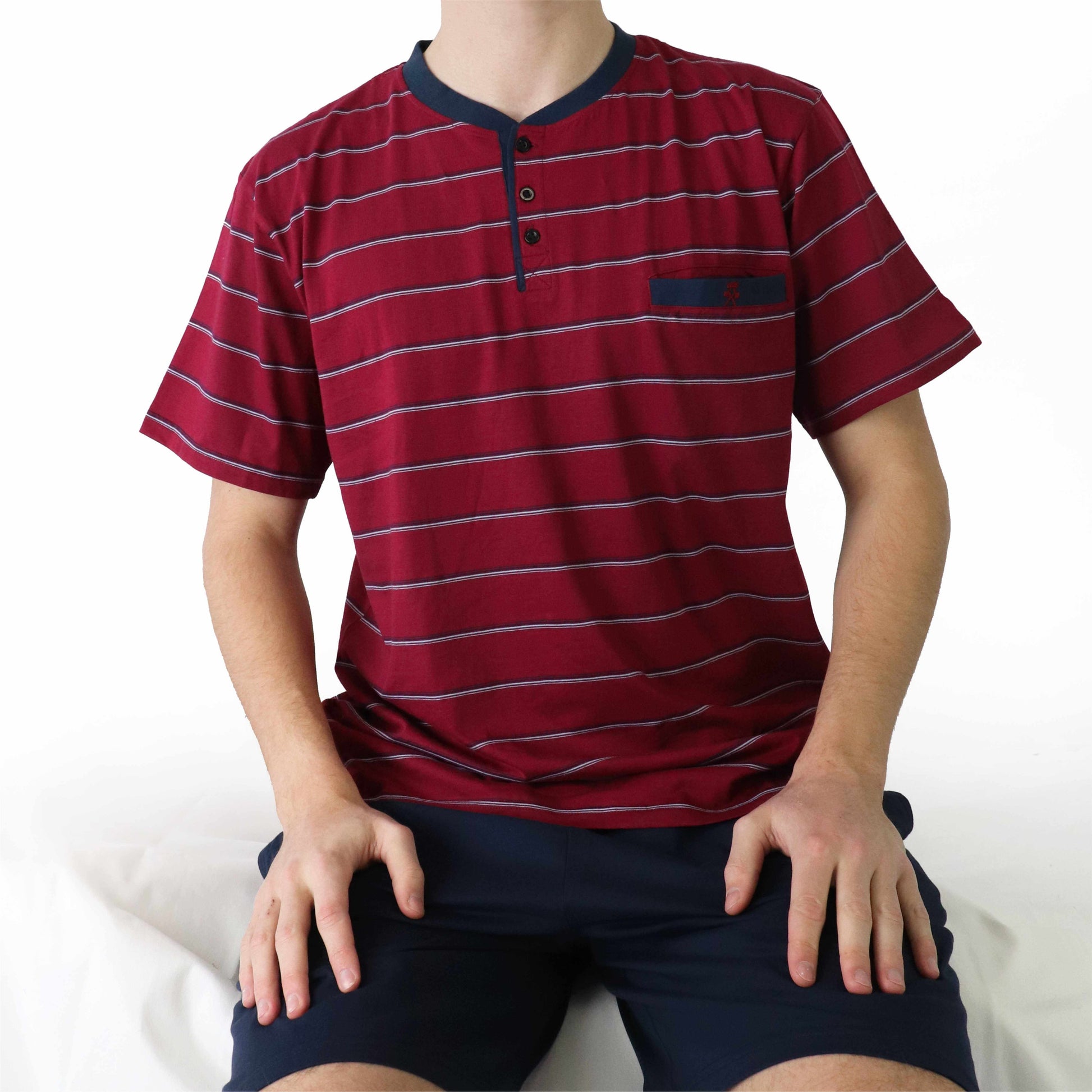 Rode gestreepte polo-shirt met korte mouwen en donkerblauwe kraag, gedragen met donkerblauwe shorts