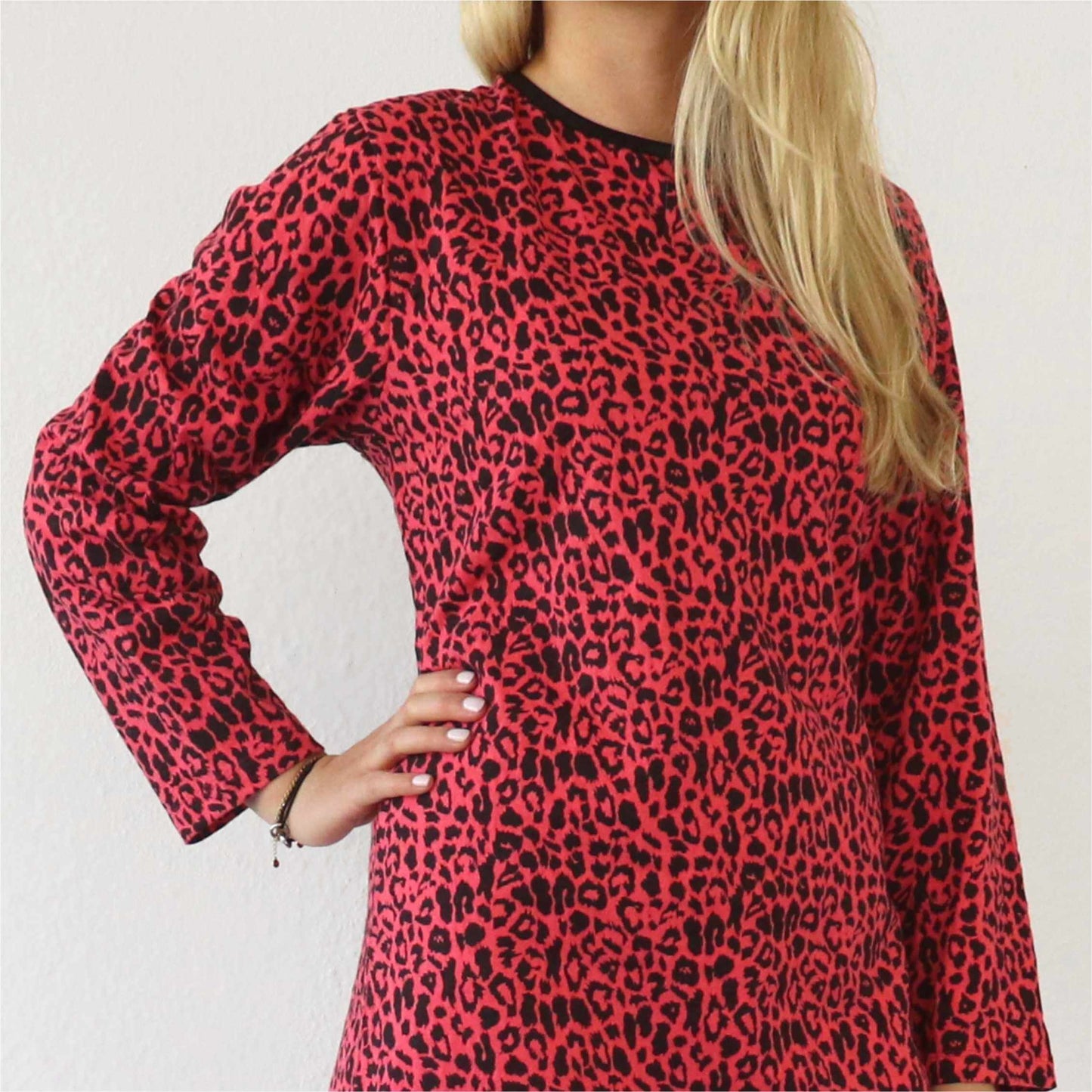 Rood nachthemd met zwart panterprint, lange mouwen en ronde hals. Blonde haren zichtbaar aan de zijkant.