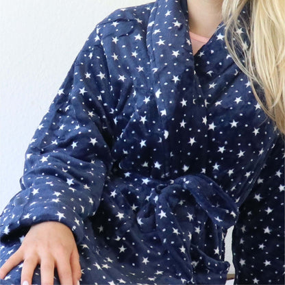 Blauwe fleece badjas met witte sterren en stippen, sjaalkraag zichtbaar, gedragen door iemand met blond haar