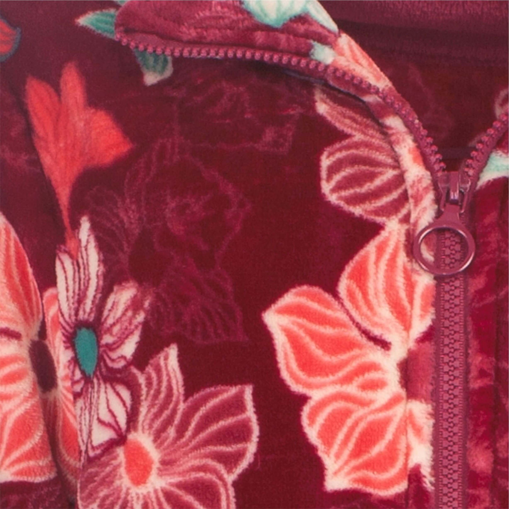 Close-up van rood gebloemde fleece stof met roze bloemenpatroon en een zichtbare rits
