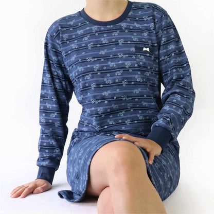 Donkerblauw fleece nachthemd met bloemetjespatroon, lange mouwen en ronde hals, gedragen door een zittende persoon.