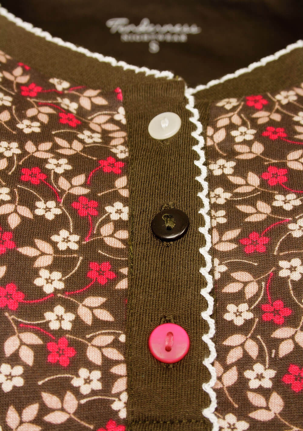 Bruin nachthemd met roze en witte bloemen, polo sluiting met witte en roze knoopjes, omzoomd met wit kant.