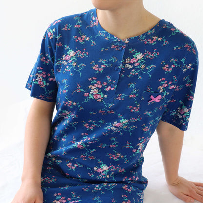 Blauw nachthemd met korte mouwen, versierd met een roze bloemenpatroon en een strikje op de borst.