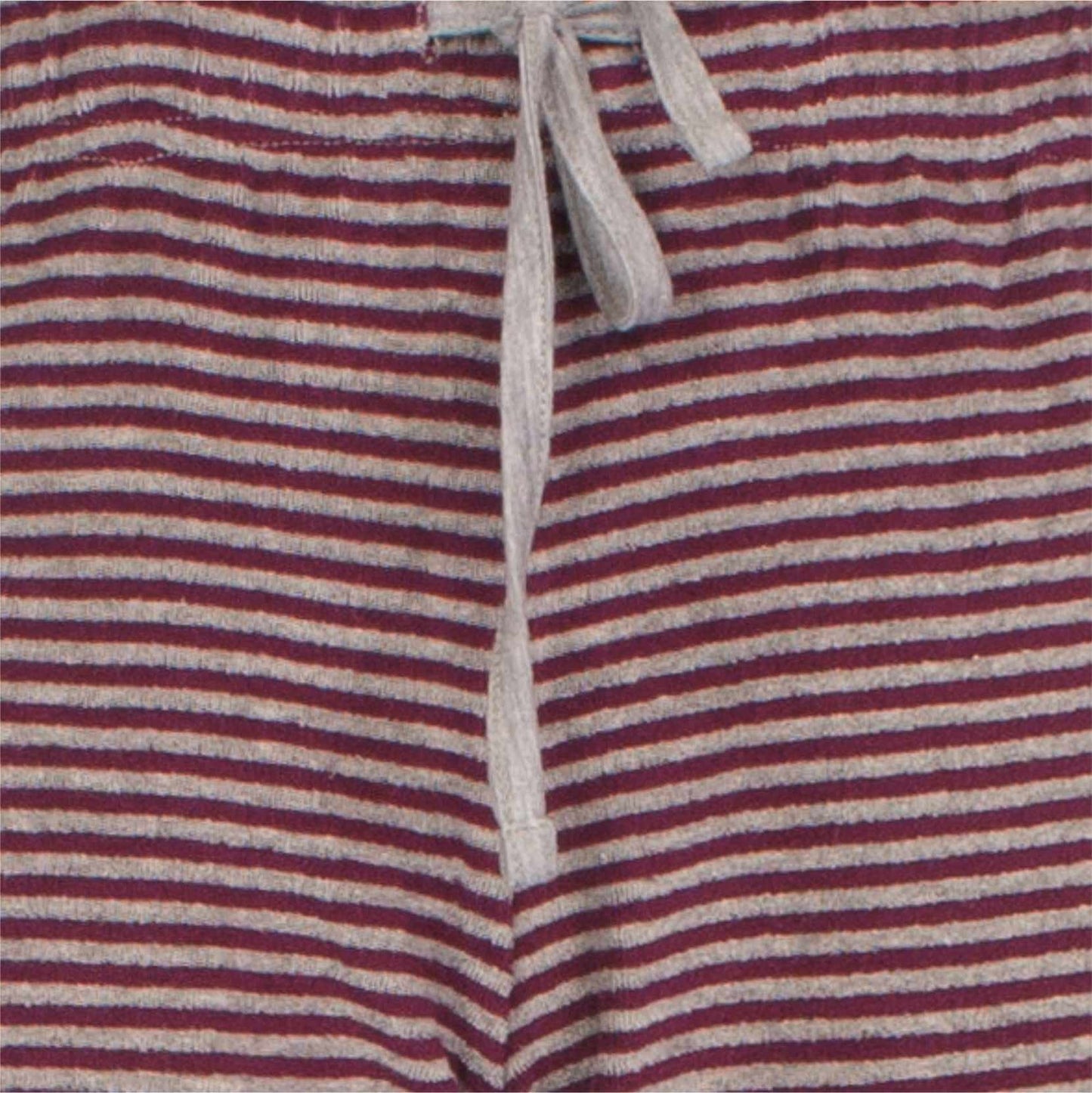 Gestreepte badstof stof in rood en grijs met een wit koord zichtbaar, waarschijnlijk van een pyjama broek.