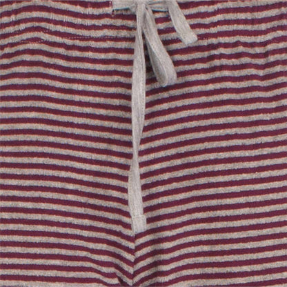 Gestreepte badstof stof in rood en grijs met een wit koord zichtbaar, waarschijnlijk van een pyjama broek.