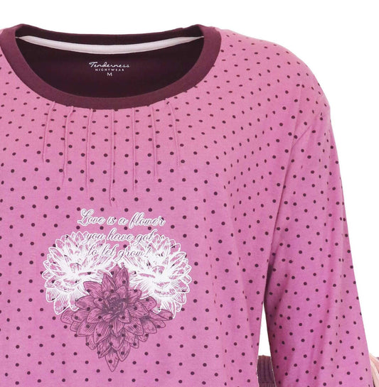 Donkerroze pyjama met stippen en bloemenprint. Opschrift 'Love is a flower you have got to let grow'.