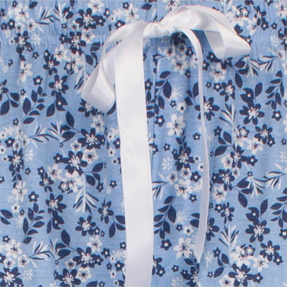 Indigo blauwe pyjama met wit bloemenpatroon en een witte strik in het midden van de afbeelding.