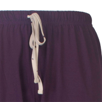 Close-up van een paarse pyjama broek met een beige koord om de taille vast te maken.