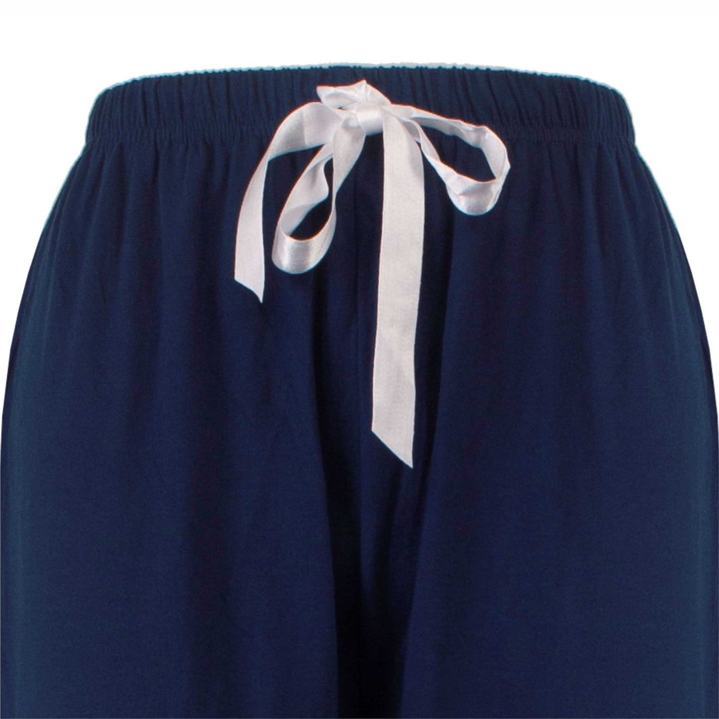 Close-up van een marineblauwe pyjamabroek met een witte strik aan de elastische tailleband.