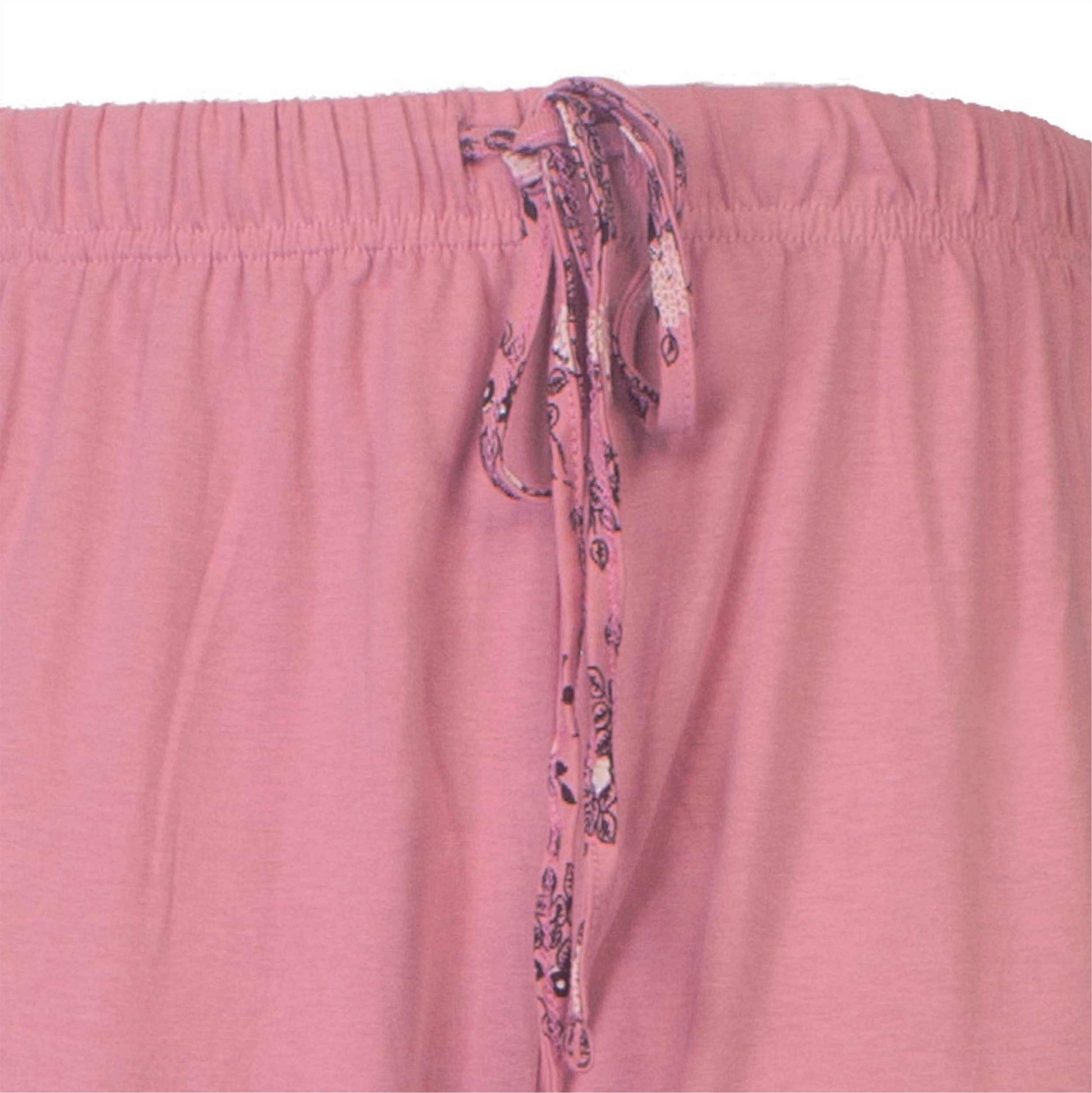 Close-up van roze pyjama broek met elastische taille en decoren decoratief koord met bloemenpatroon