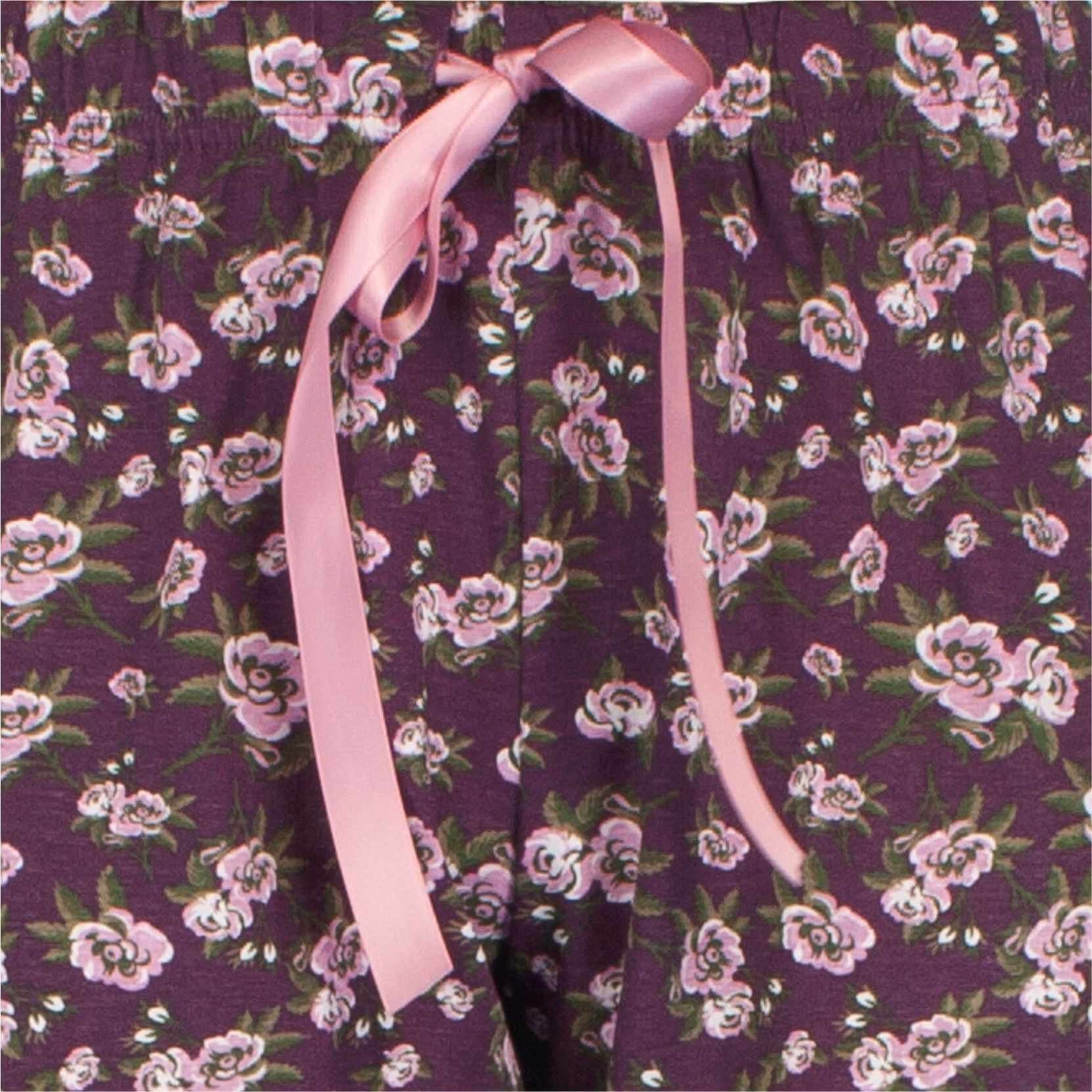 Paarse pyjama met roze bloemenprint en een roze lint vastgemaakt aan de kraag