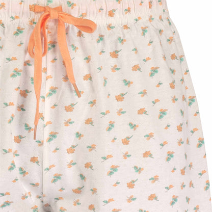 Witte shortama met oranje en groene bloemenprint, oranje strik bij de taille, mouwloos ontwerp