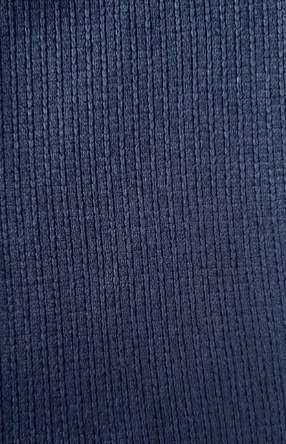 Close-up van donkerblauwe fleece stof met verticale ribbelstructuur, zacht en comfortabel ogend.